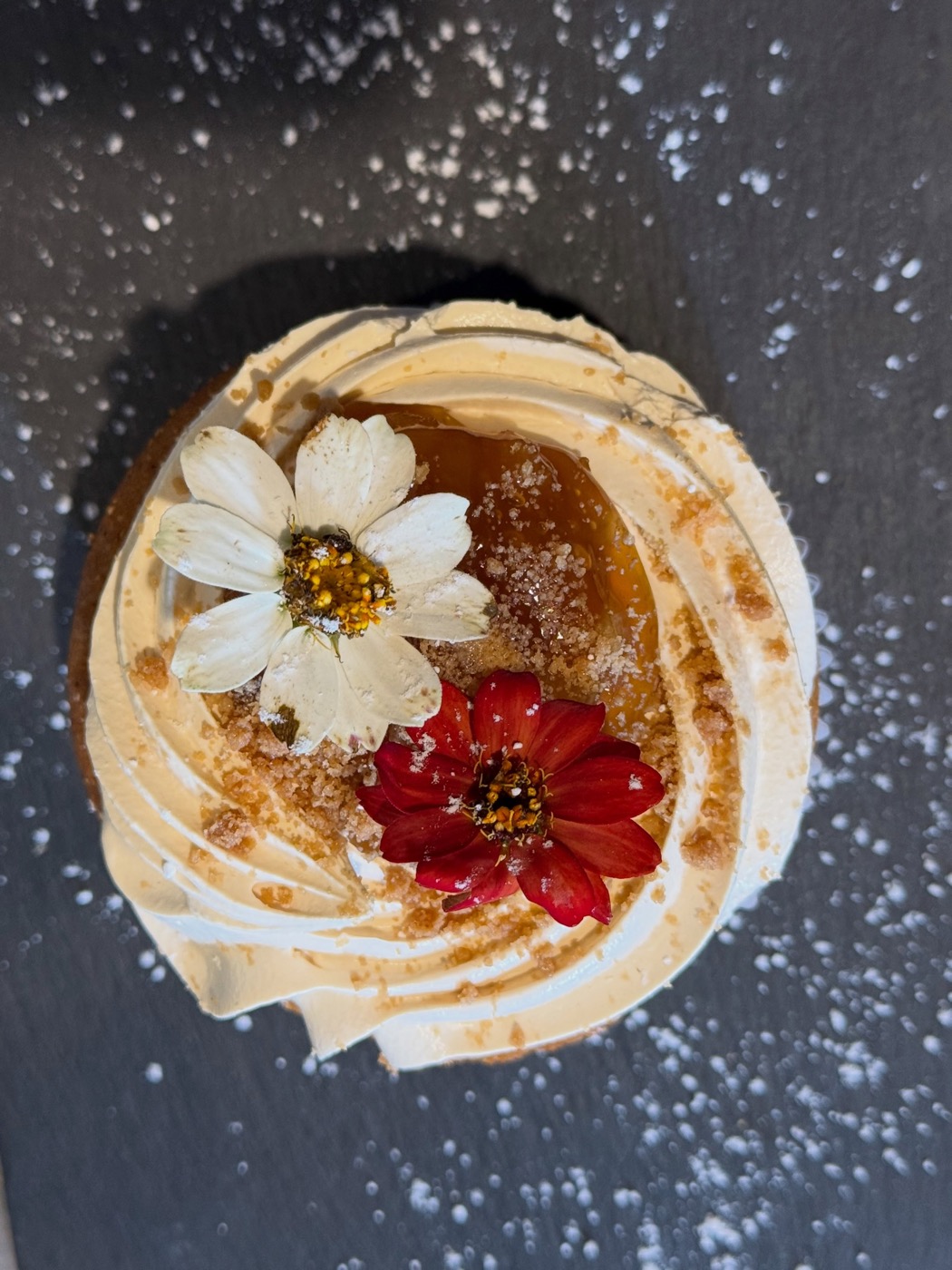 A tart topped with cream and edible flowers